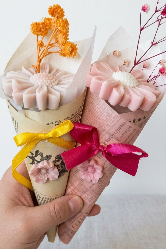 Bouquets de fleurs en cire dans leurs cornets en papier, noués de rubans colorés